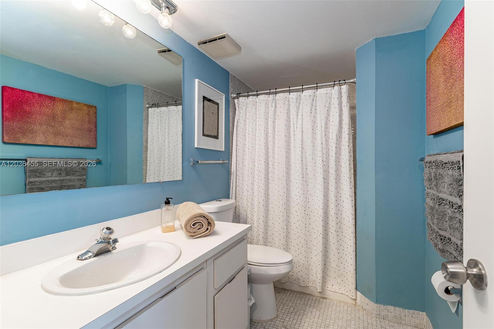 780 Northeast 69th Street, Unit 1010 Miami, FL 33138 - Photo 28 of 31 a bathroom with a sink a toilet and shower curtain