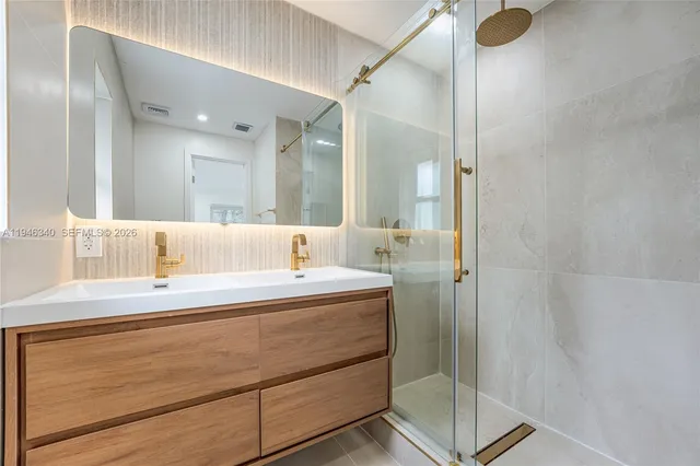 a bathroom with a sink mirror toilet and shower