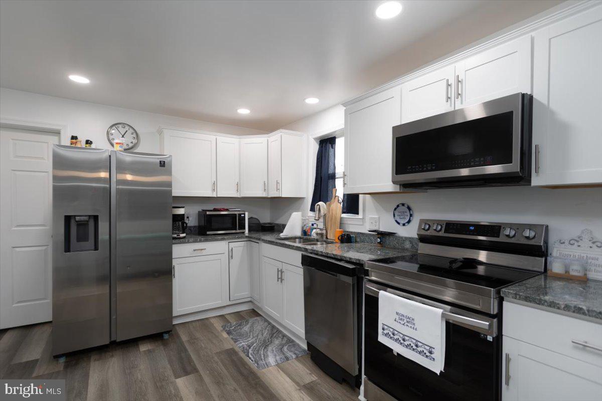 728 Race Street Cambridge, MD 21613 - Photo 4 of 14 a kitchen with a sink a microwave a refrigerator and cabinets
