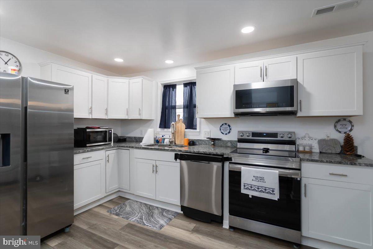 728 Race Street Cambridge, MD 21613 - Photo 5 of 14 a kitchen with stainless steel appliances a stove a sink a refrigerator and cabinets