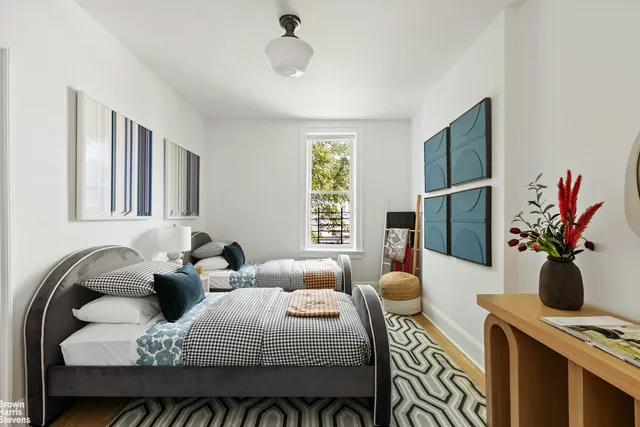 a bed sitting in a bedroom next to a window