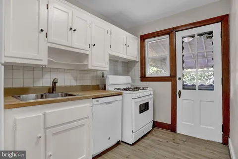 a kitchen with white cabinets and appliances