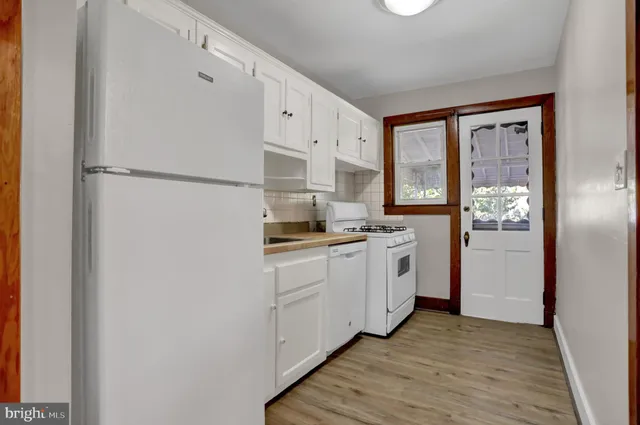 a kitchen with white cabinets and white appliances