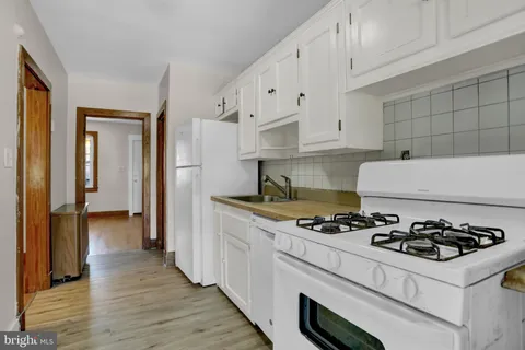 a kitchen with granite countertop a sink stove and refrigerator