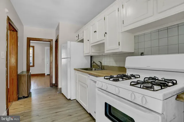 a kitchen with granite countertop a sink stove and refrigerator