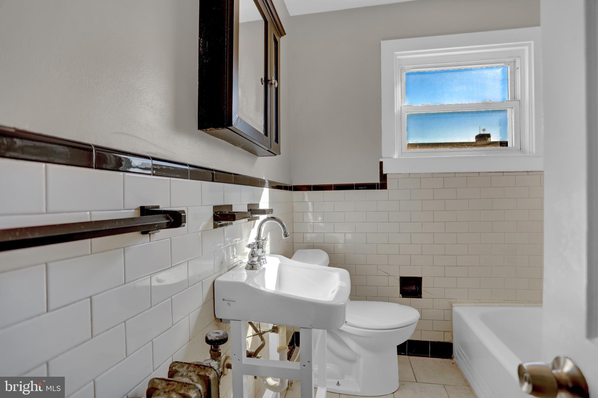 714 Rappolla Street Baltimore, MD 21224 - Photo 22 of 36 a bathroom with a toilet a sink and mirror