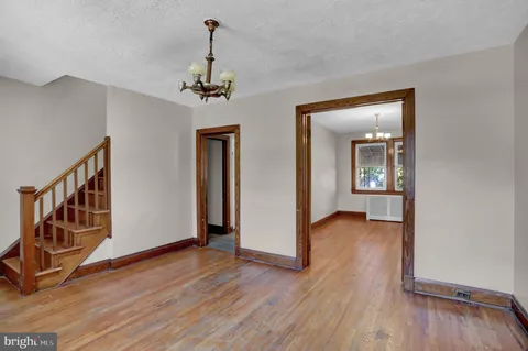 a view of a hallway with wooden floor and staircase