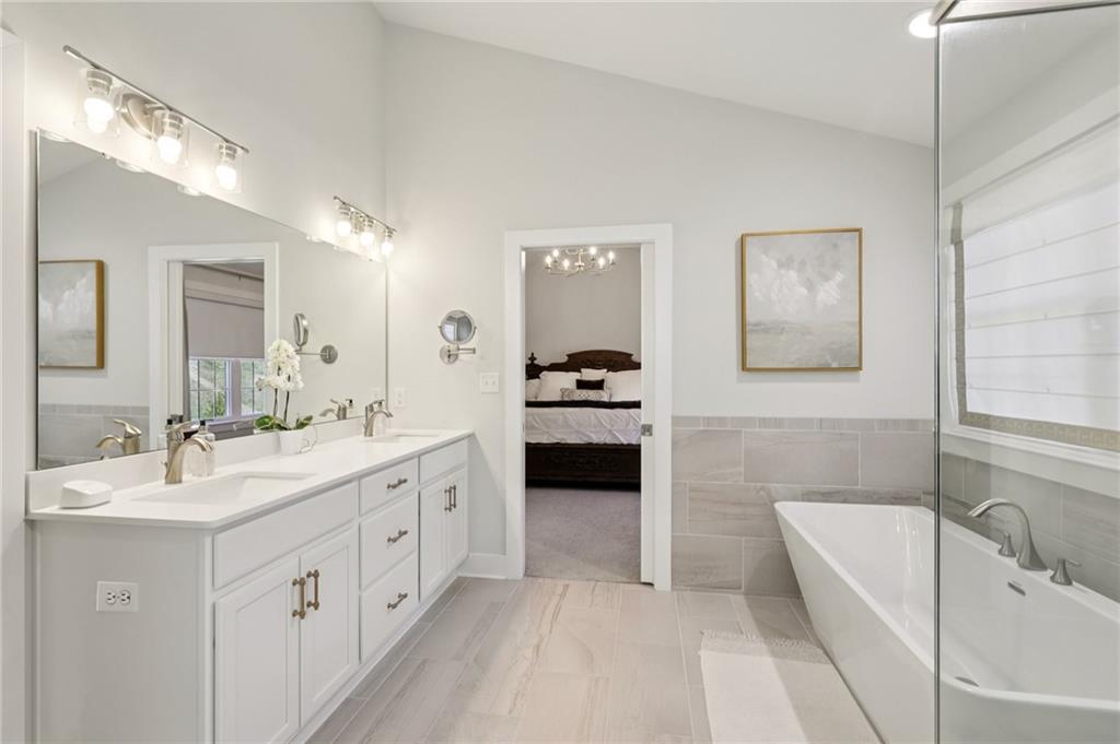 216 Hickory Lane Mars, PA 16046 - Photo 27 of 50 a spacious en suite bathroom with a double vanity sink a tub a mirror and vanity