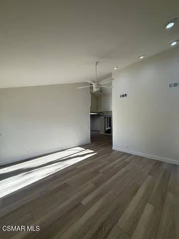 a view of empty room with wooden floor
