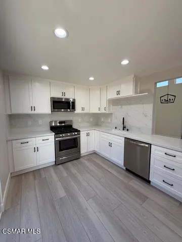 a kitchen with granite countertop a stove top oven and cabinets