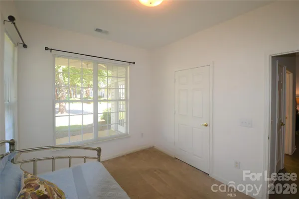 a spacious bedroom with a bed and a window
