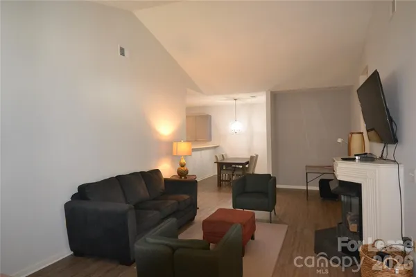 a living room with furniture a fireplace and a flat screen tv