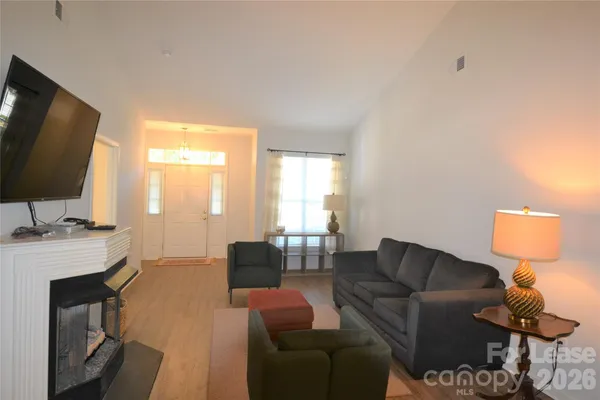 a living room with furniture a fireplace and a flat screen tv