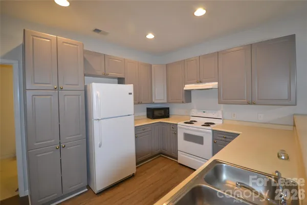a kitchen with a refrigerator sink stove and cabinets
