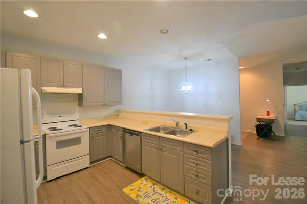 a kitchen with a sink cabinets and wooden floor