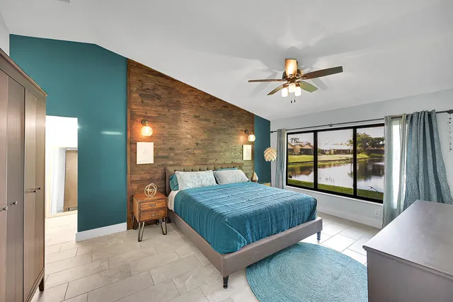 a bedroom with a bed and a large window with outer view