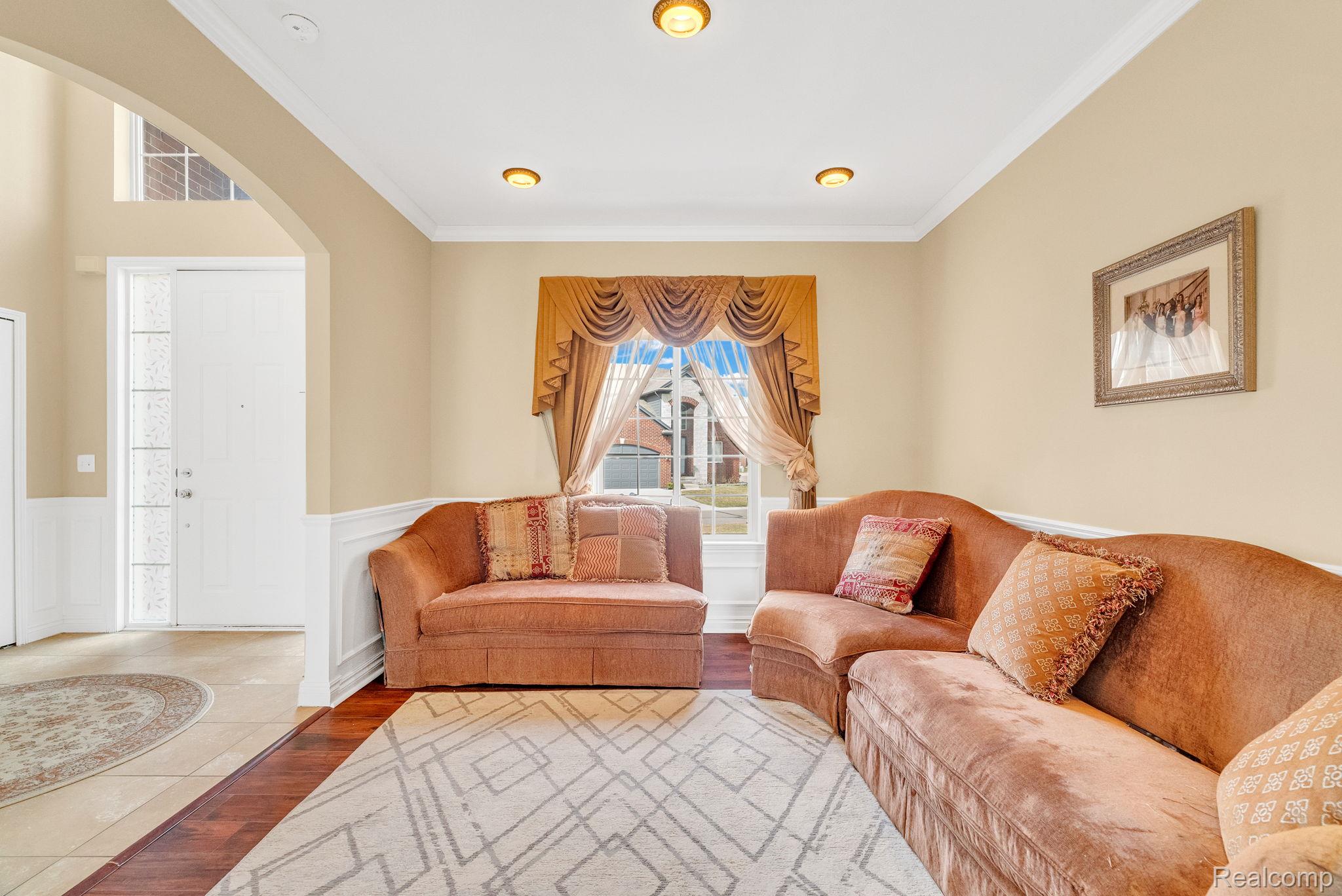 4122 Hawks Nest Road Utica, MI 48317 - Photo 18 of 74 Living area with ornamental molding, wood finished floors, wainscoting, and arched walkways