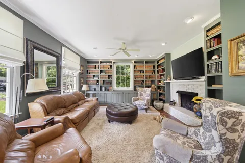 a living room with furniture a fireplace and a flat screen tv