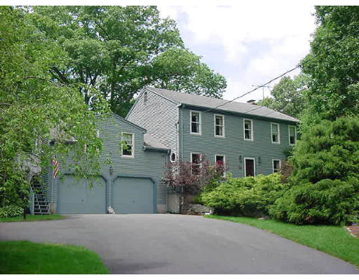 a front view of a house with a yard and trees