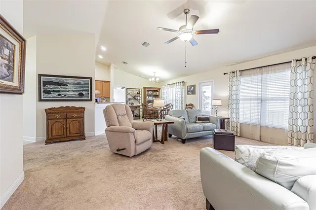a living room with furniture a fireplace and a chandelier