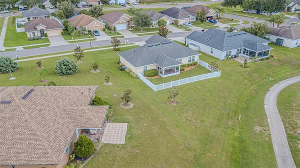 an aerial view of residential houses with outdoor space and parking