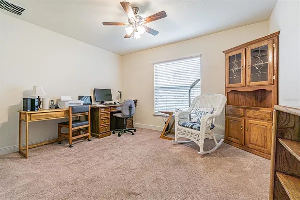 a view of a workspace with furniture and a window