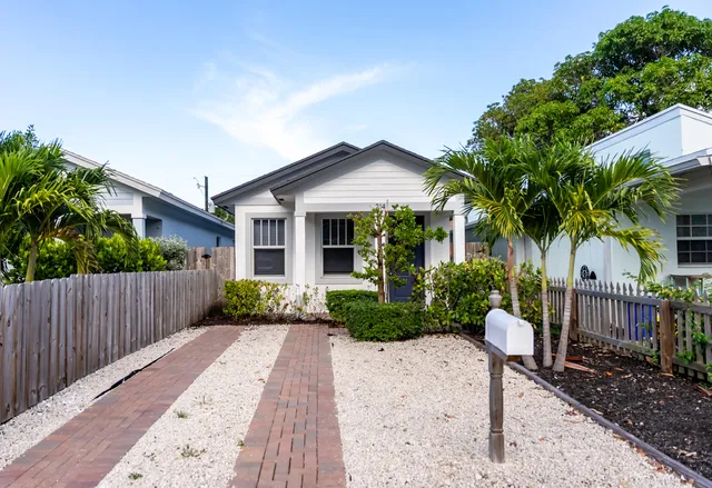 a front view of a house with a yard and garden