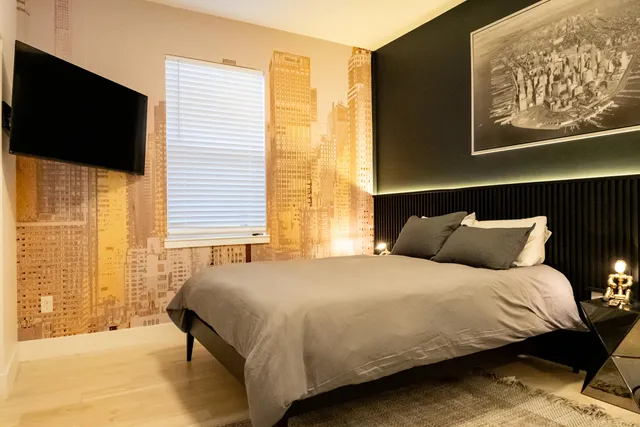 a bedroom with a bed tv and a window