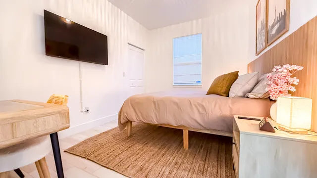 a bedroom with a bed and a flat screen tv