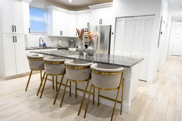 a kitchen with a dining table chairs and refrigerator