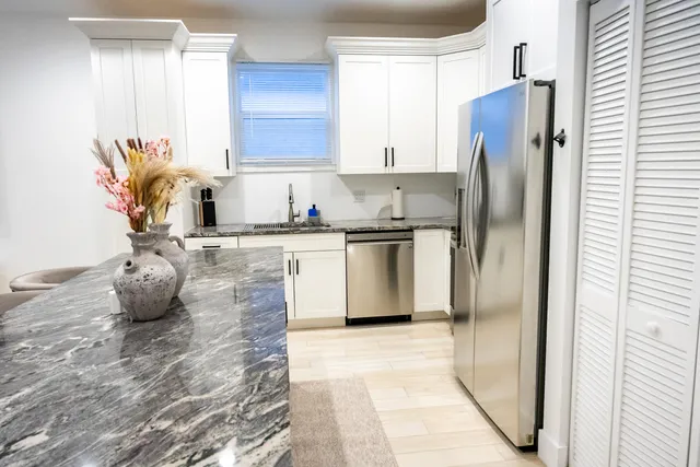 a kitchen with stainless steel appliances a refrigerator sink and cabinets