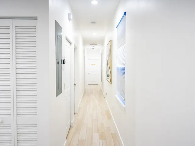 a view of a hallway with wooden floor and staircase