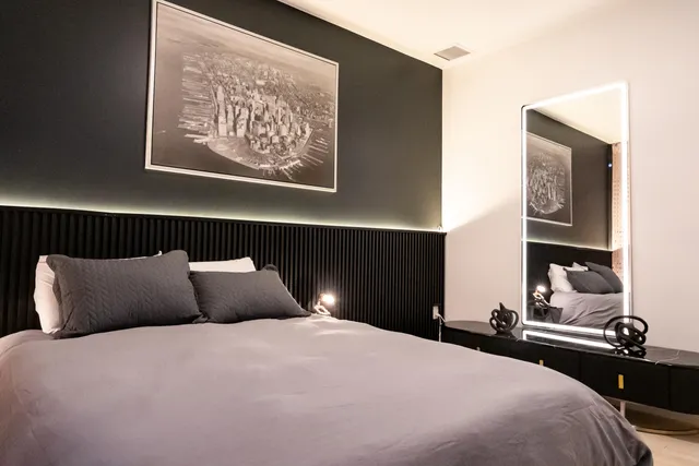 a bedroom with a bed and a painting on the wall