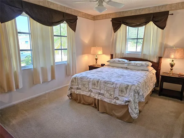 a bed sitting in a spacious bedroom next to a window