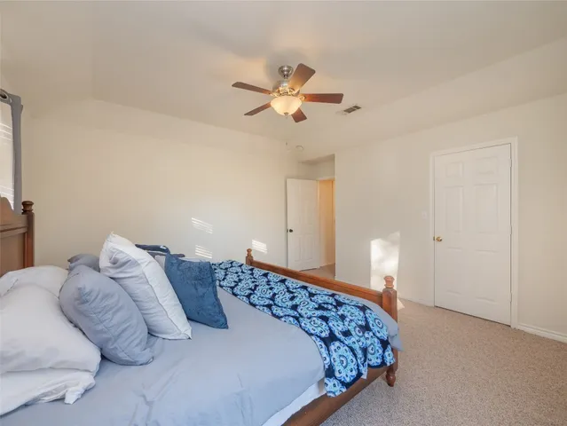 a bedroom with a bed and a ceiling fan