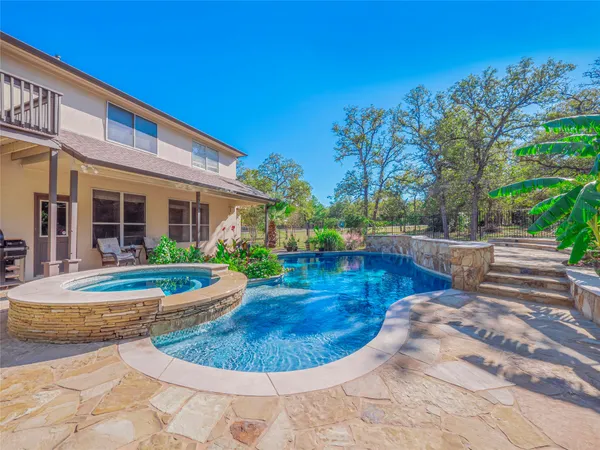 a view of a backyard with swimming pool