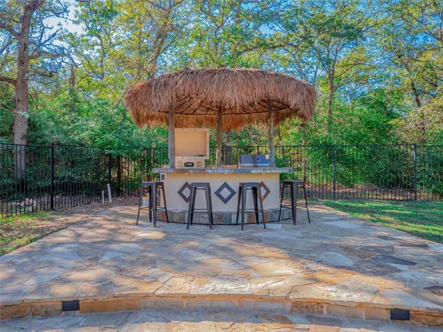 a view of a table and chairs under an umbrella in backyard