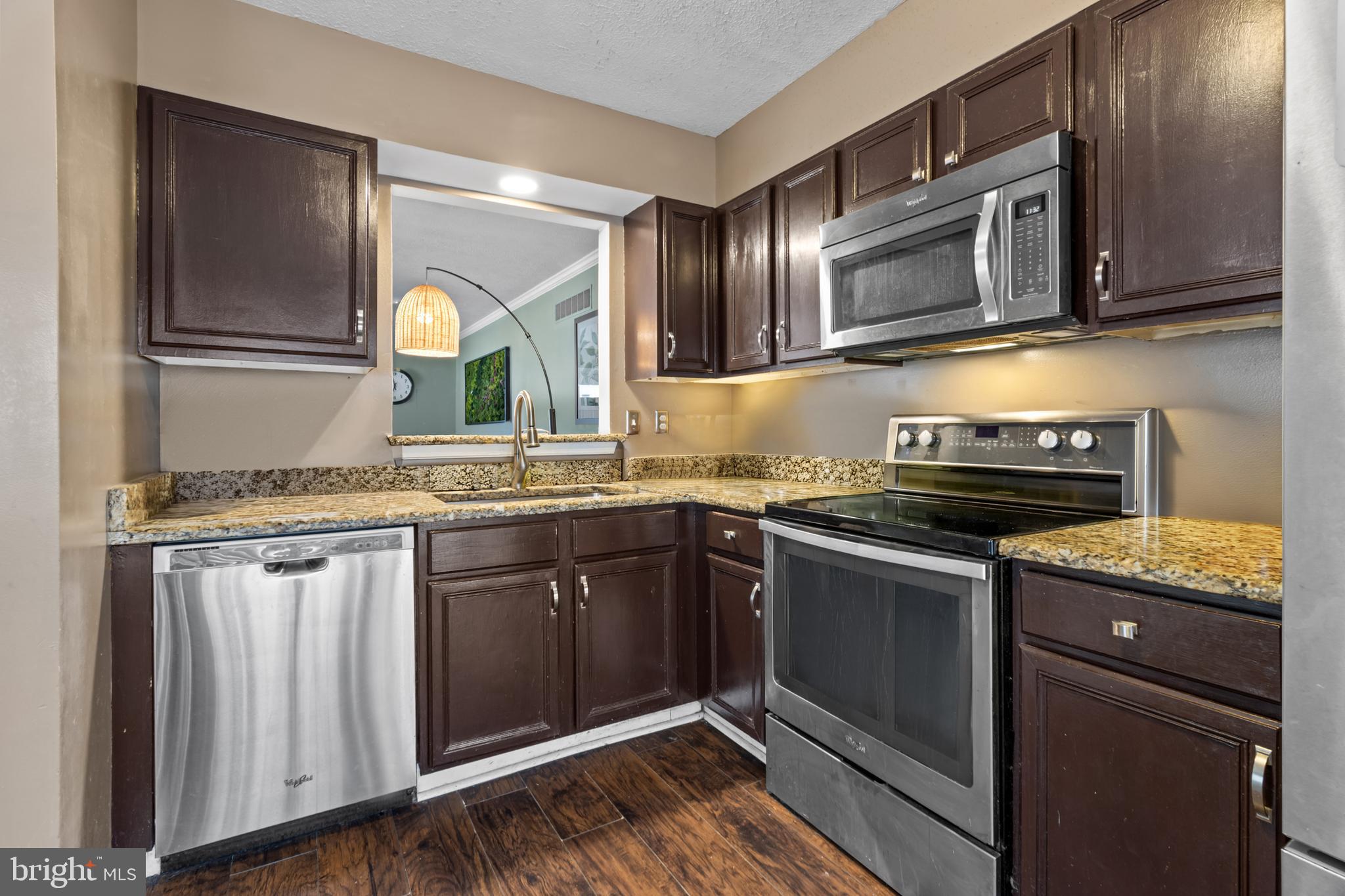 115 Balmoral Way Newark, DE 19702 - Photo 9 of 31 a kitchen with granite countertop stainless steel appliances and wooden cabinets