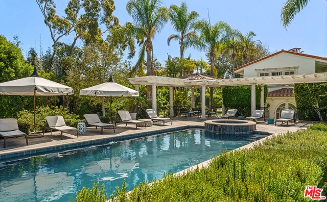 a view of pool with table and chairs under an umbrella