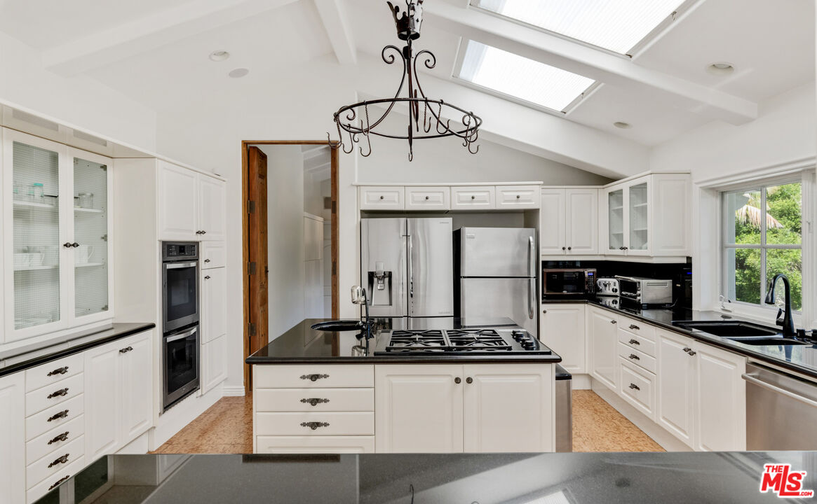 28899 Cliffside Drive Malibu, CA 90265 - Photo 14 of 53 a kitchen with stainless steel appliances a counter space a sink a window and cabinets