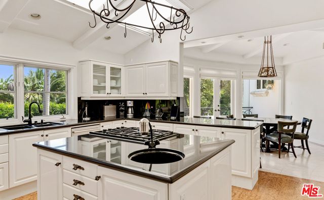 a kitchen with a stove a sink a dining table and chairs