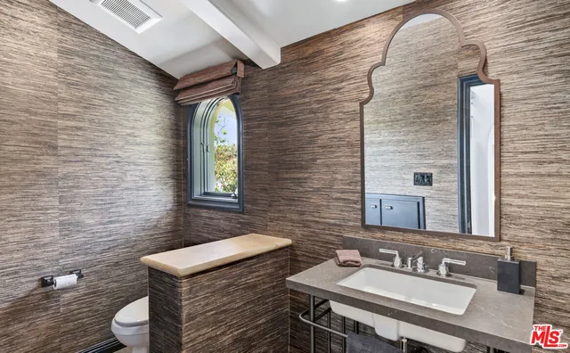 a bathroom with a sink a toilet and mirror