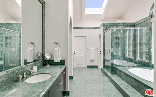 a spacious bathroom with a granite countertop tub sink and mirror