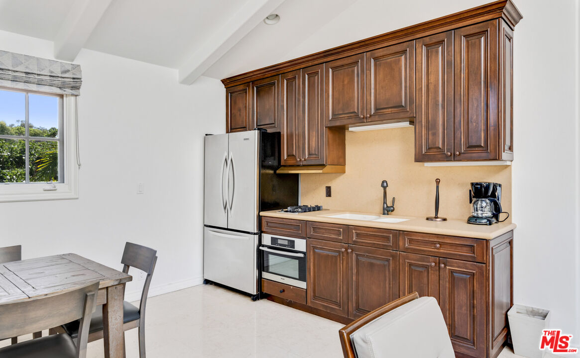 28899 Cliffside Drive Malibu, CA 90265 - Photo 49 of 53 a kitchen with stainless steel appliances a stove refrigerator sink and cabinets