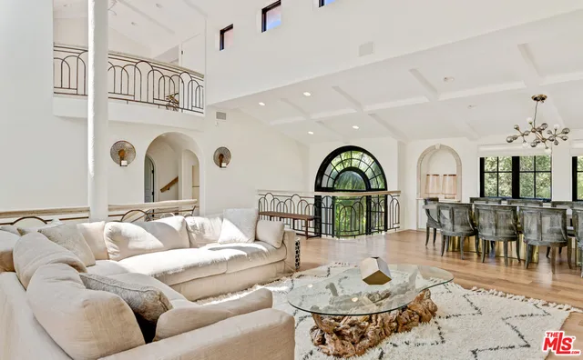 a living room with furniture a fireplace and a chandelier