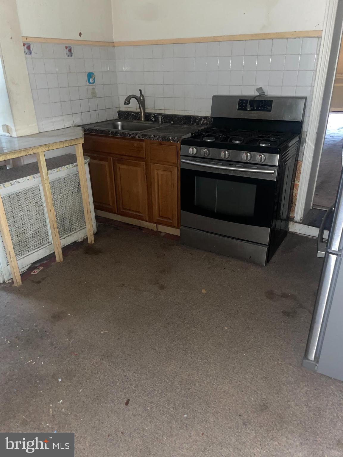 449 Delmar Street Philadelphia, PA 19128 - Photo 4 of 13 a kitchen with granite countertop a stove and a sink