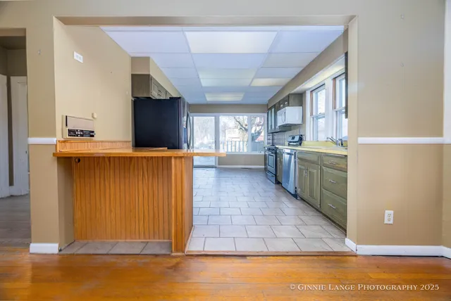 a kitchen with a sink a refrigerator and cabinets