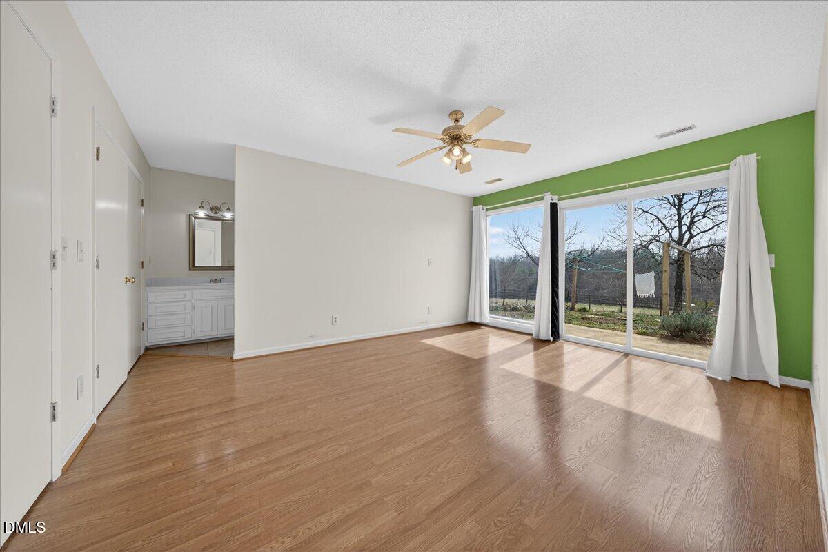 180 Manor Drive Timberlake, NC 27583 - Photo 14 of 85 a view of an empty room with a window and wooden floor