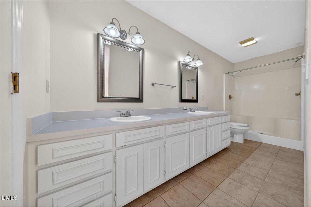 180 Manor Drive Timberlake, NC 27583 - Photo 20 of 85 a bathroom with a double vanity sink and a mirror