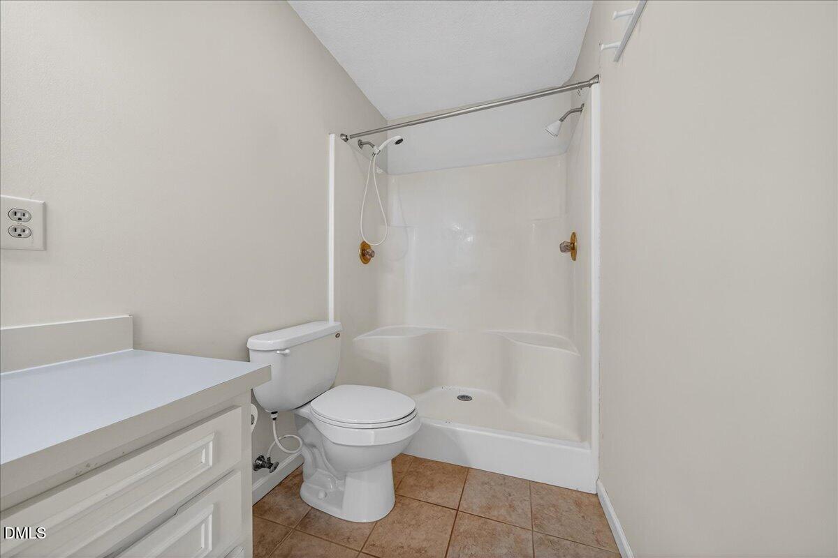180 Manor Drive Timberlake, NC 27583 - Photo 21 of 85 a white toilet sitting next to a bathroom sink and vanity